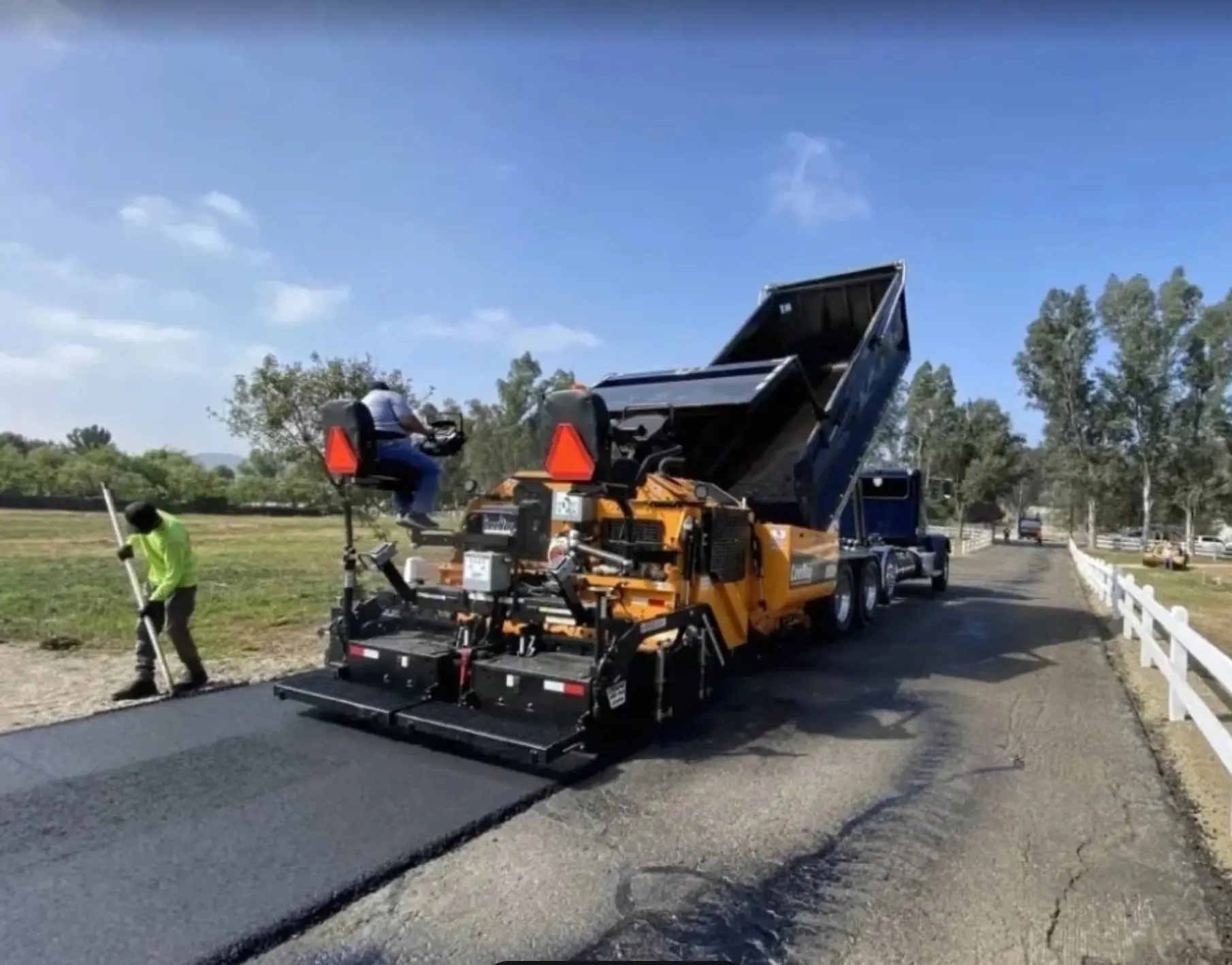 Pave N Seal crew laying fresh asphalt with a paver near Baltimore