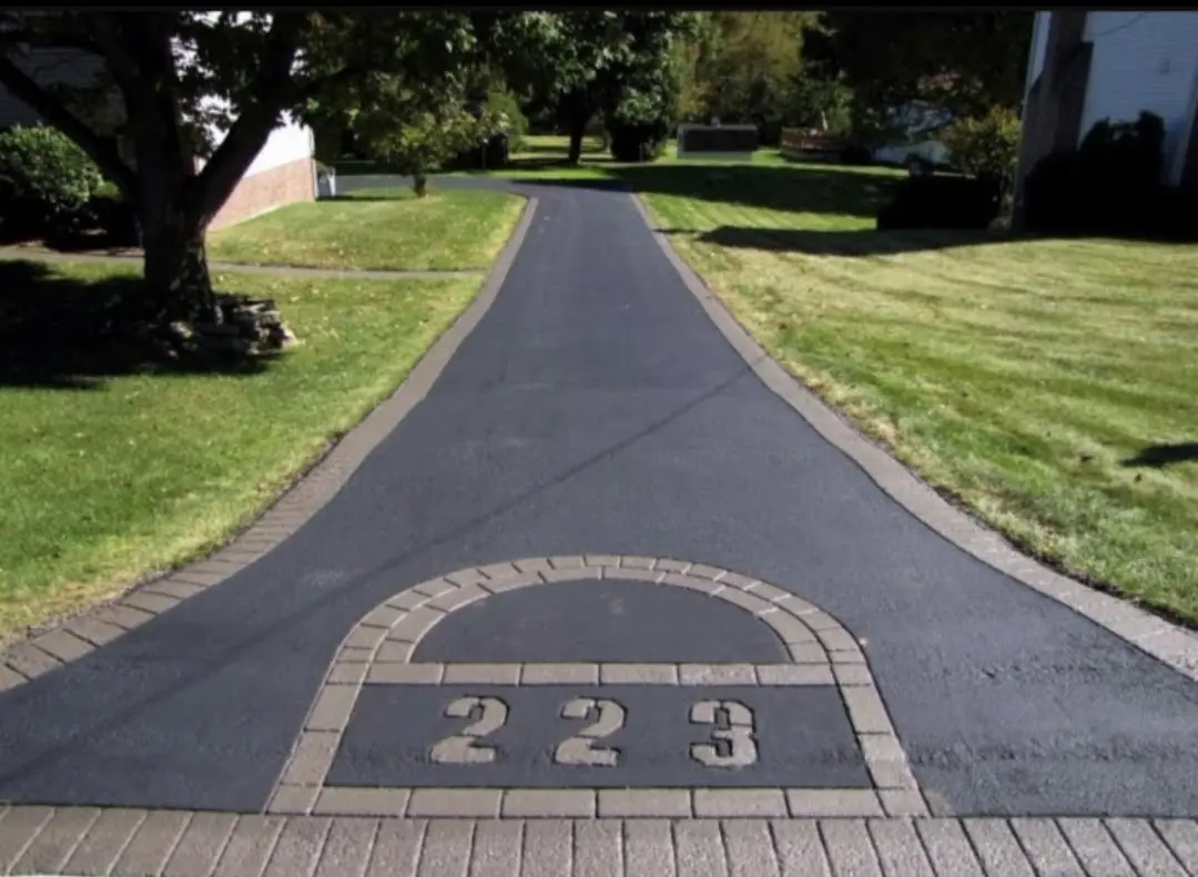 Freshly paved residential driveway with stamped brick border in Baltimore